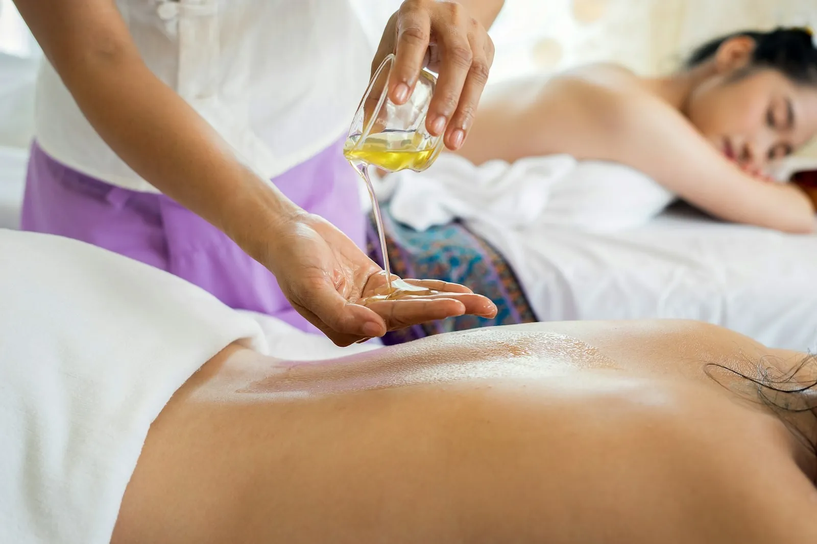 Terapeuta aplicando aceite durante un masaje
