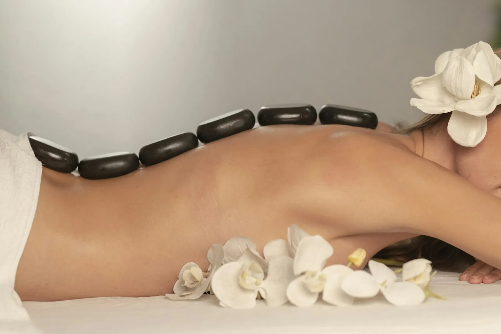 Masaje con piedras calientes y flores