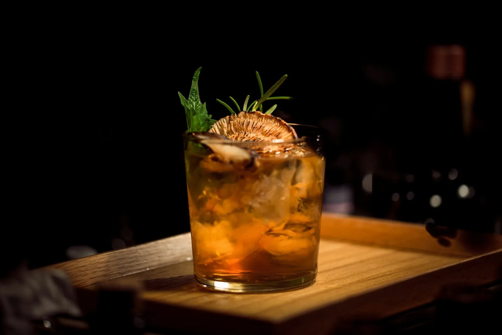 Cocktail with herbs on a wooden bar